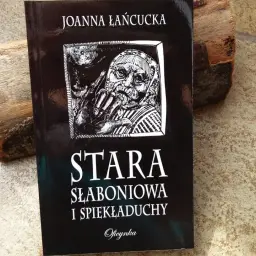 Okładka książki "Stara słaboniowa i spiekładuchy" Joanny Łańcuckiej, z mrocznym, symbolicznym rysunkiem.